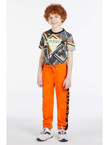 Детски памучен спортен панталон Guess в оранжево с апликация