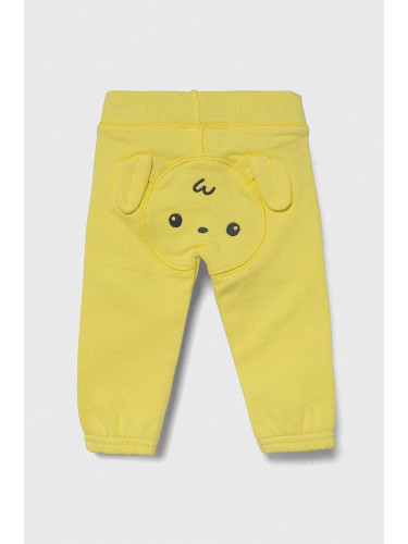 Бебешки памучен спортен панталон United Colors of Benetton в жълто с апликация