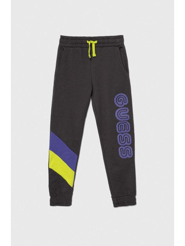 Детски памучен спортен панталон Guess в сиво с апликация