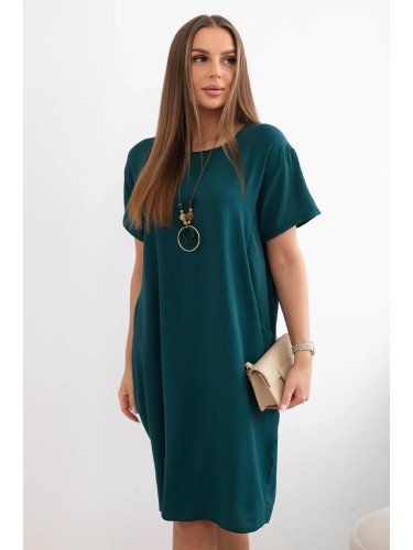 Dress with pockets and a pendant in dark green